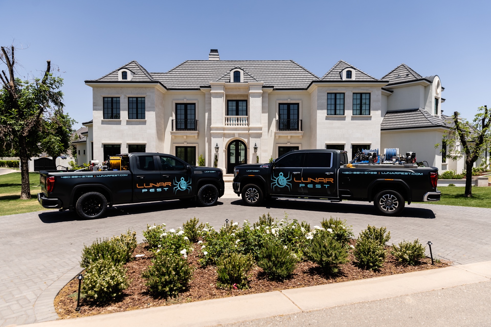 Lunar Pest Control trucks in front of an Arizona home